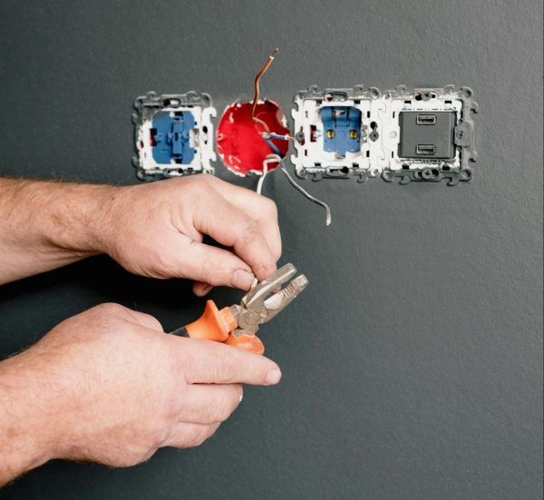 (Electricians)-(An Electrician Using Pliers to Repair the AC Power Plugs and Sockets)